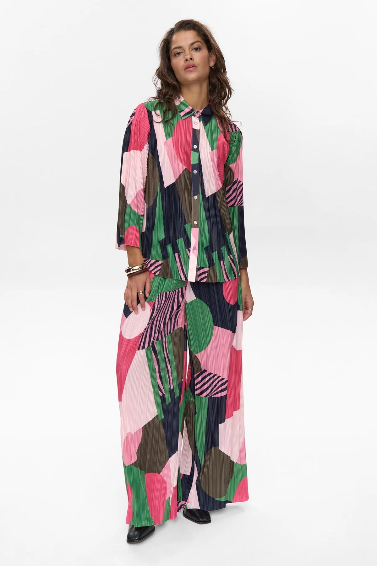 Woman wearing a colorful geometric patterned outfit on a white background