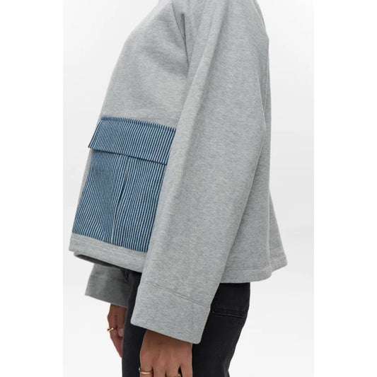 Grey sweatshirt with a blue patch on a white background