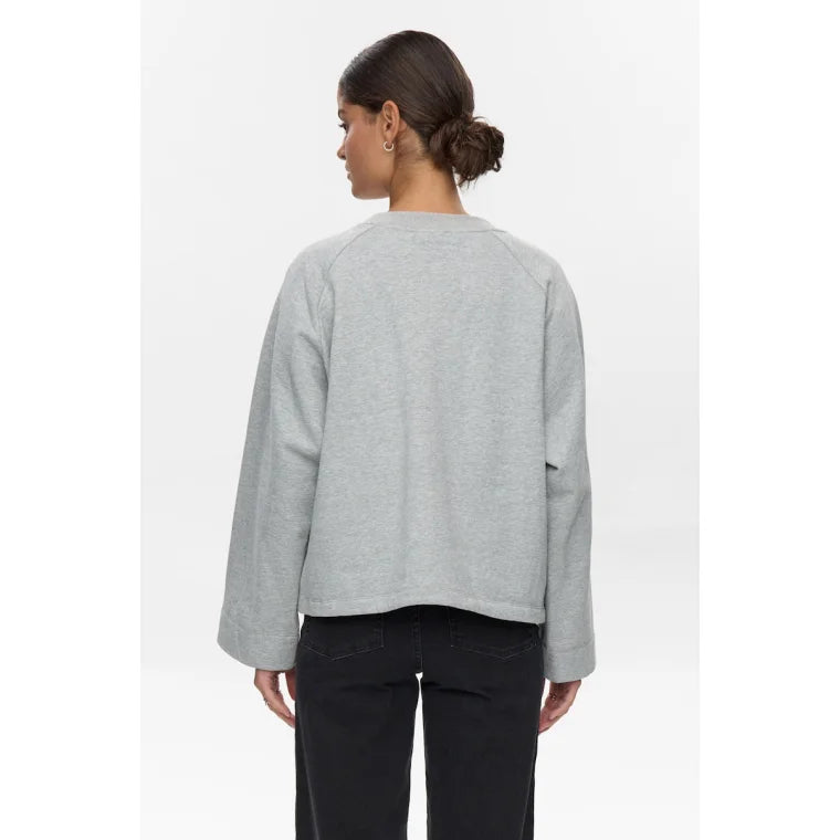 Person wearing a grey sweater on a white background