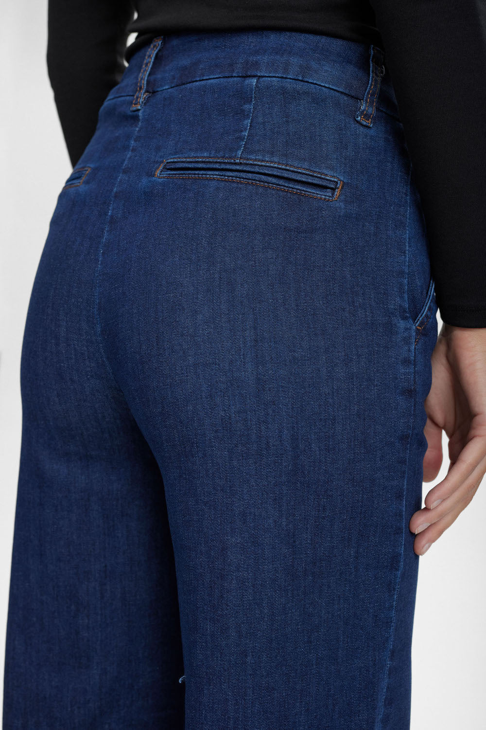 Blue jeans worn by a person on a white background
