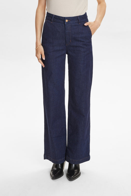 Person wearing navy wide-leg jeans on a white background