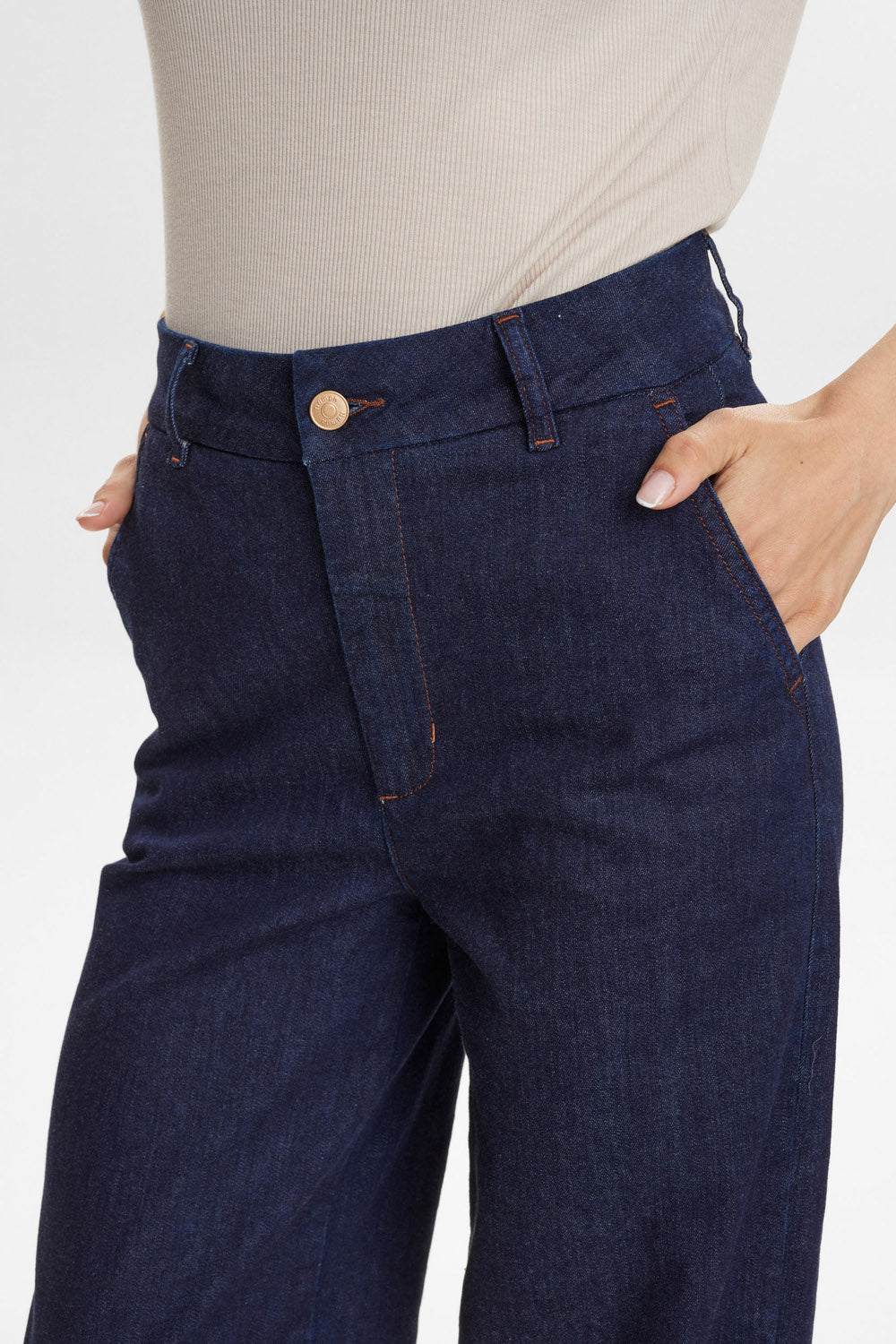 Navy blue jeans worn by a person on a white background