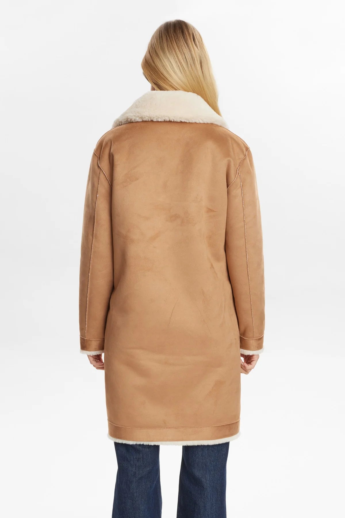 Tan coat with white fur lining worn by a person on a white background