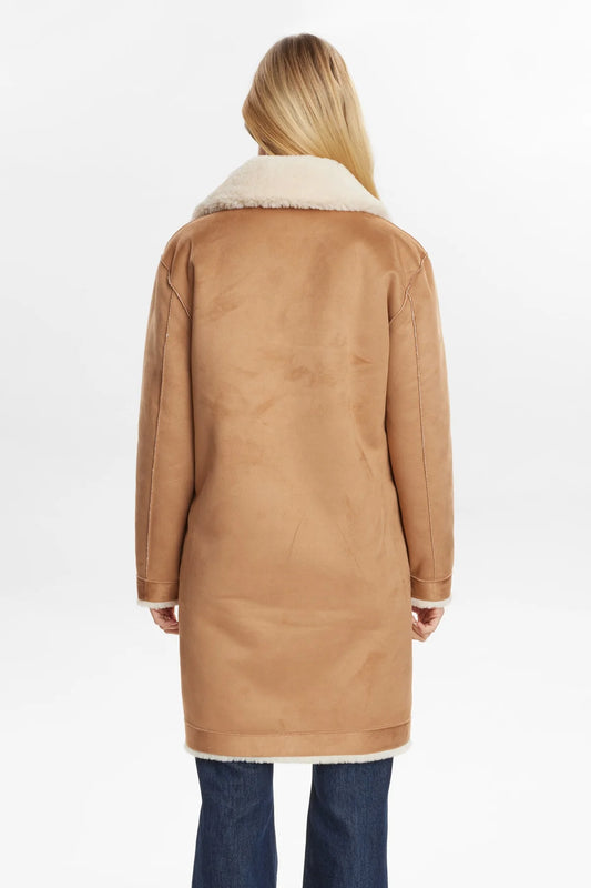 Tan coat with white fur lining worn by a person on a white background