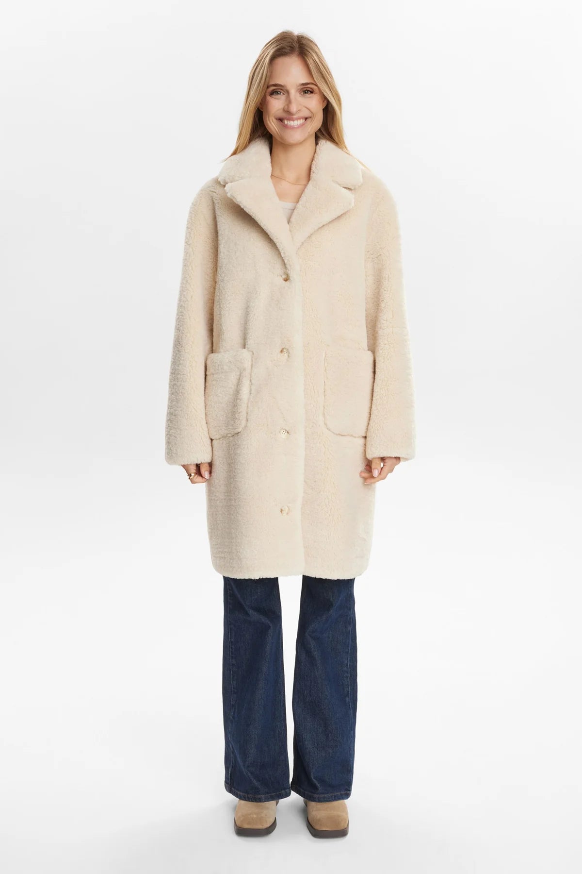 Woman wearing a beige coat on a white background