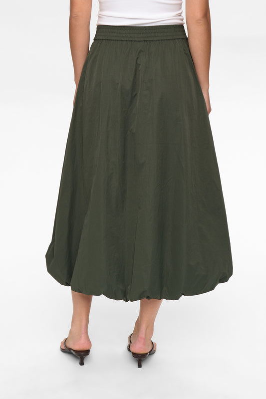 Person wearing a green skirt on a white background