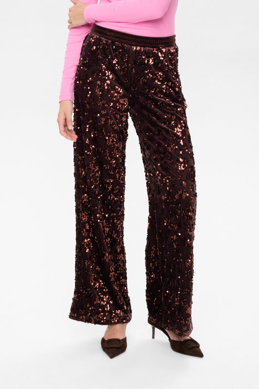 Person wearing brown sequin pants on a white background