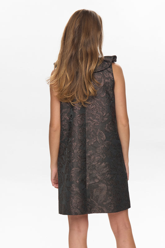 Woman wearing a sleeveless black dress with floral pattern on a white background