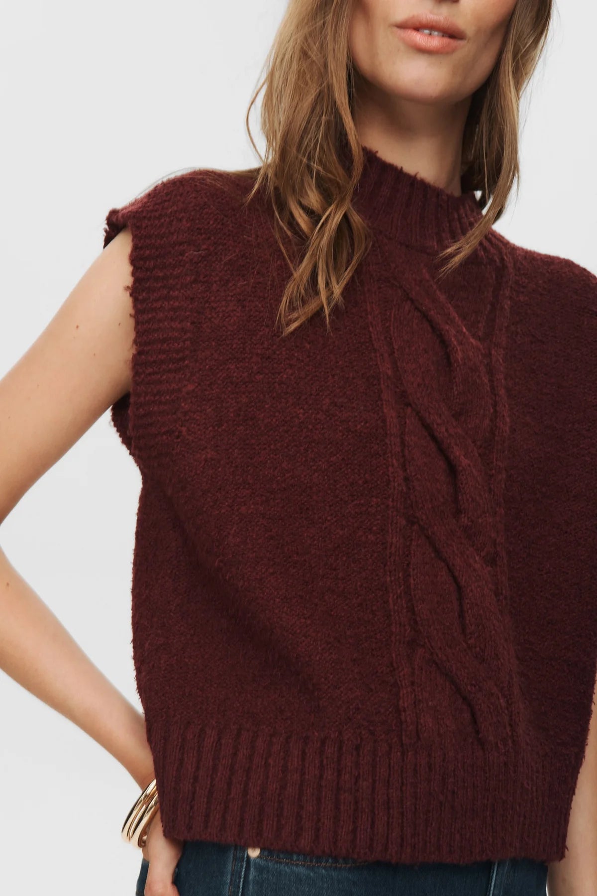 Brown knitted vest worn by a person on a white background