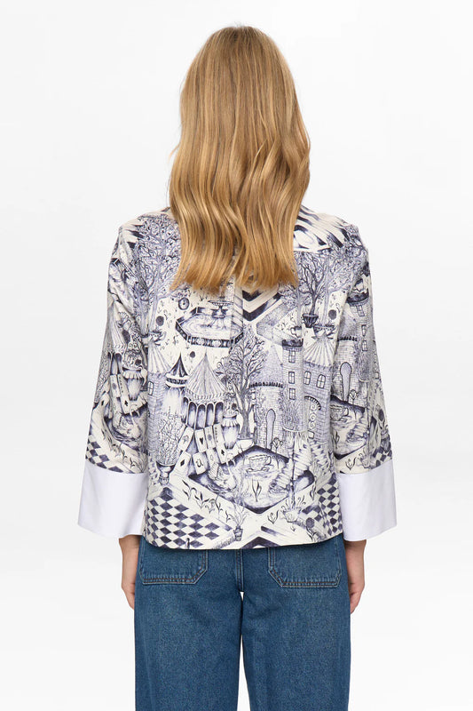 Person wearing a patterned blouse with a white background