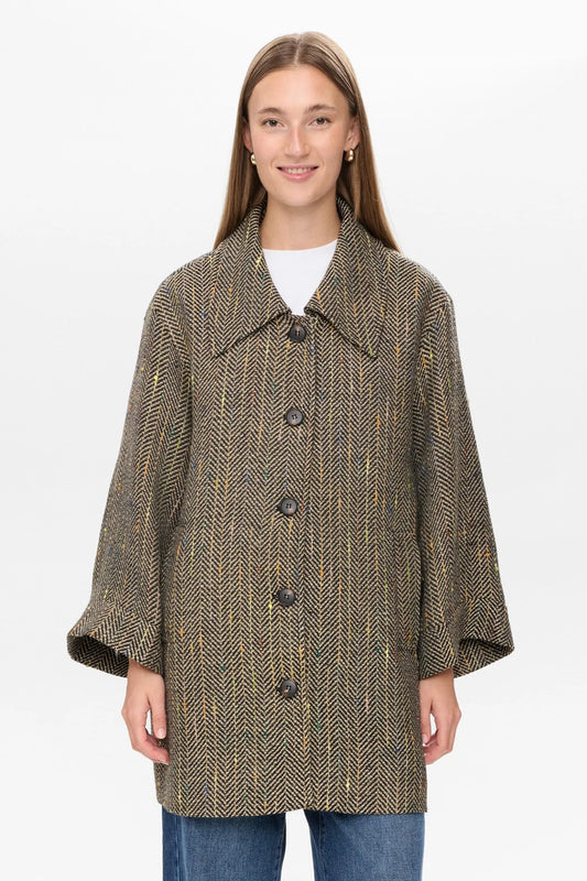 Woman wearing a tweed coat on a white background