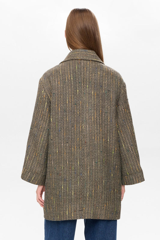 Woman wearing a patterned coat on a white background