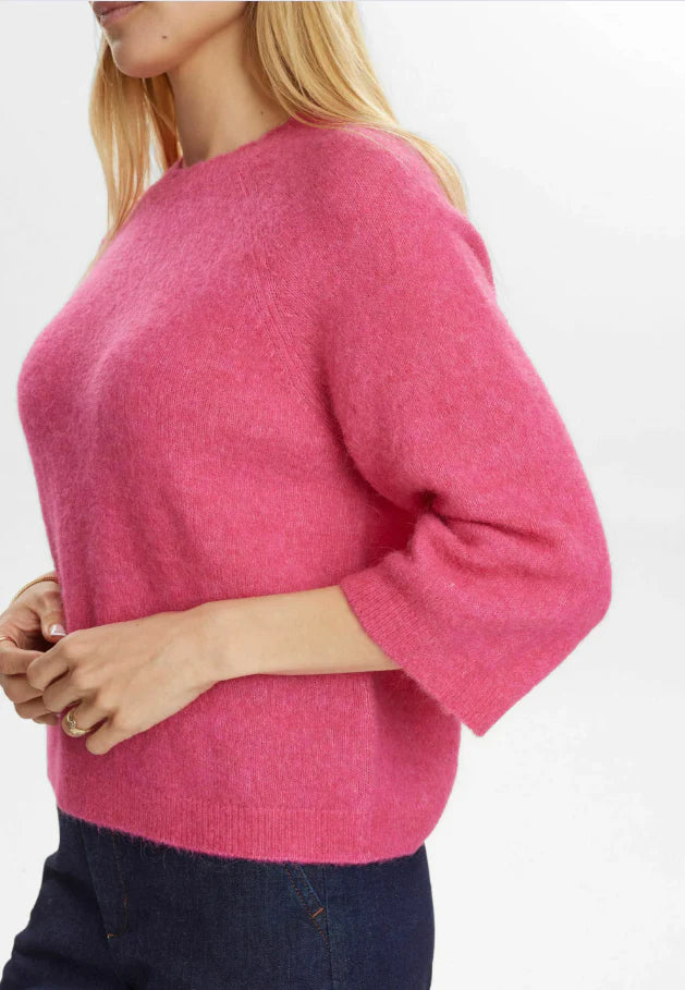 Person wearing a pink sweater on a white background