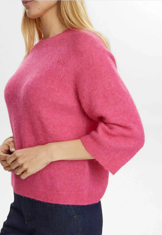 Person wearing a pink sweater on a white background