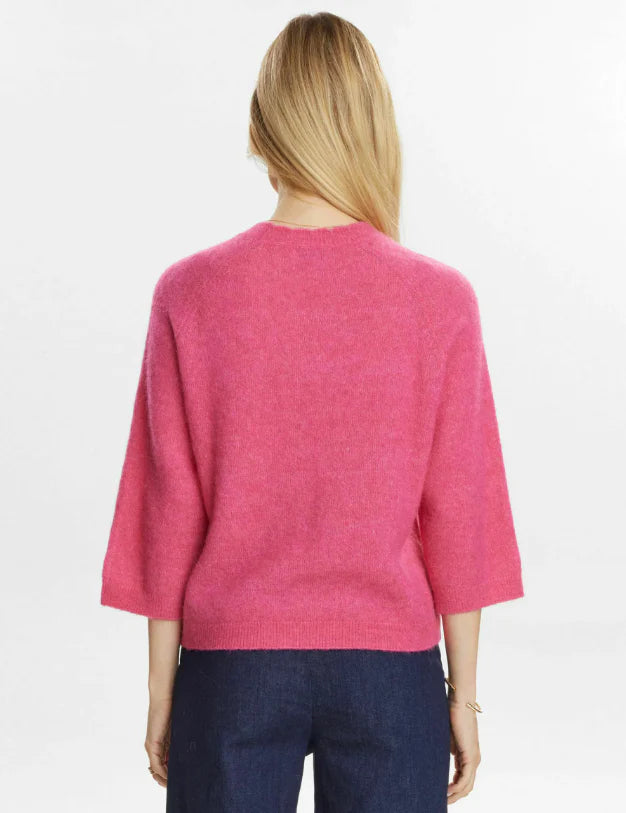 Person wearing a pink sweater on a white background