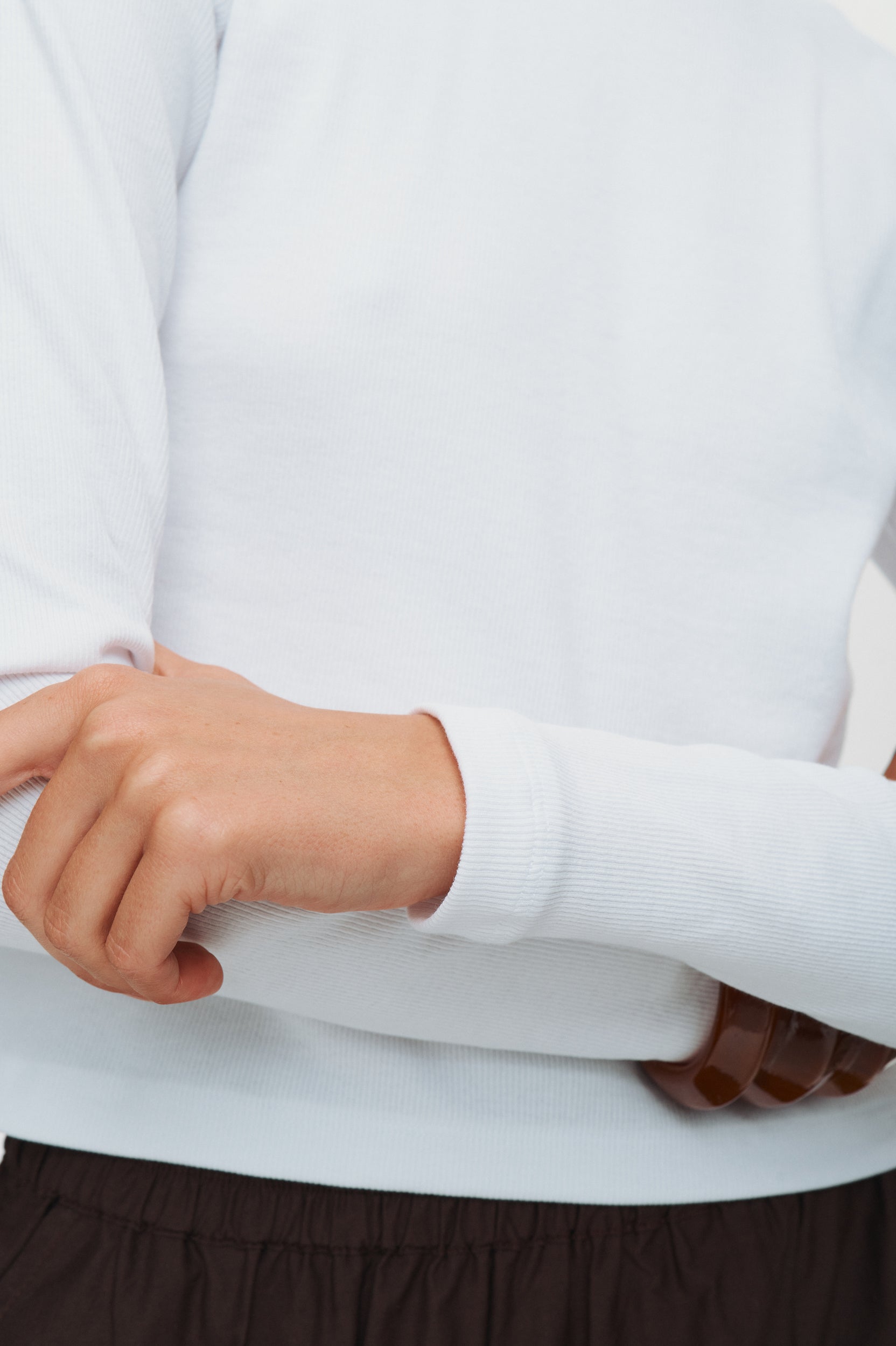 Close-up of a person wearing a light gray sweater with a blurred background