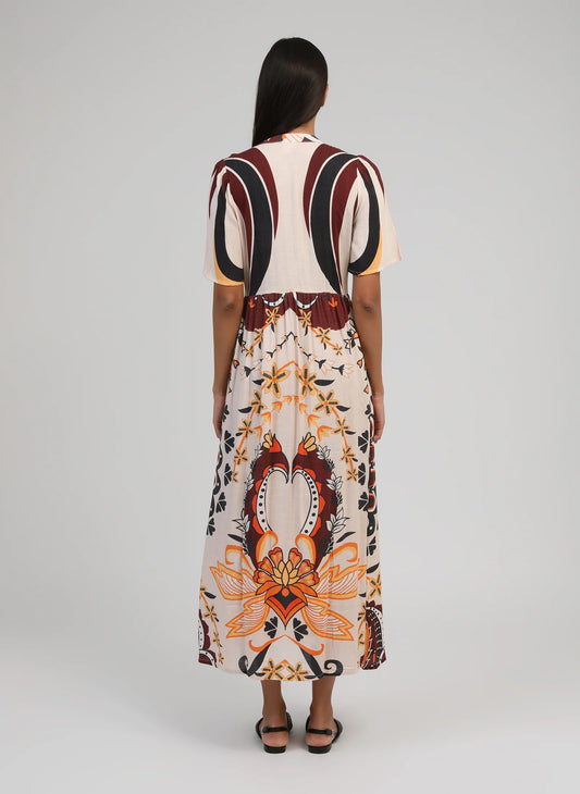 Woman wearing a patterned dress with a neutral background