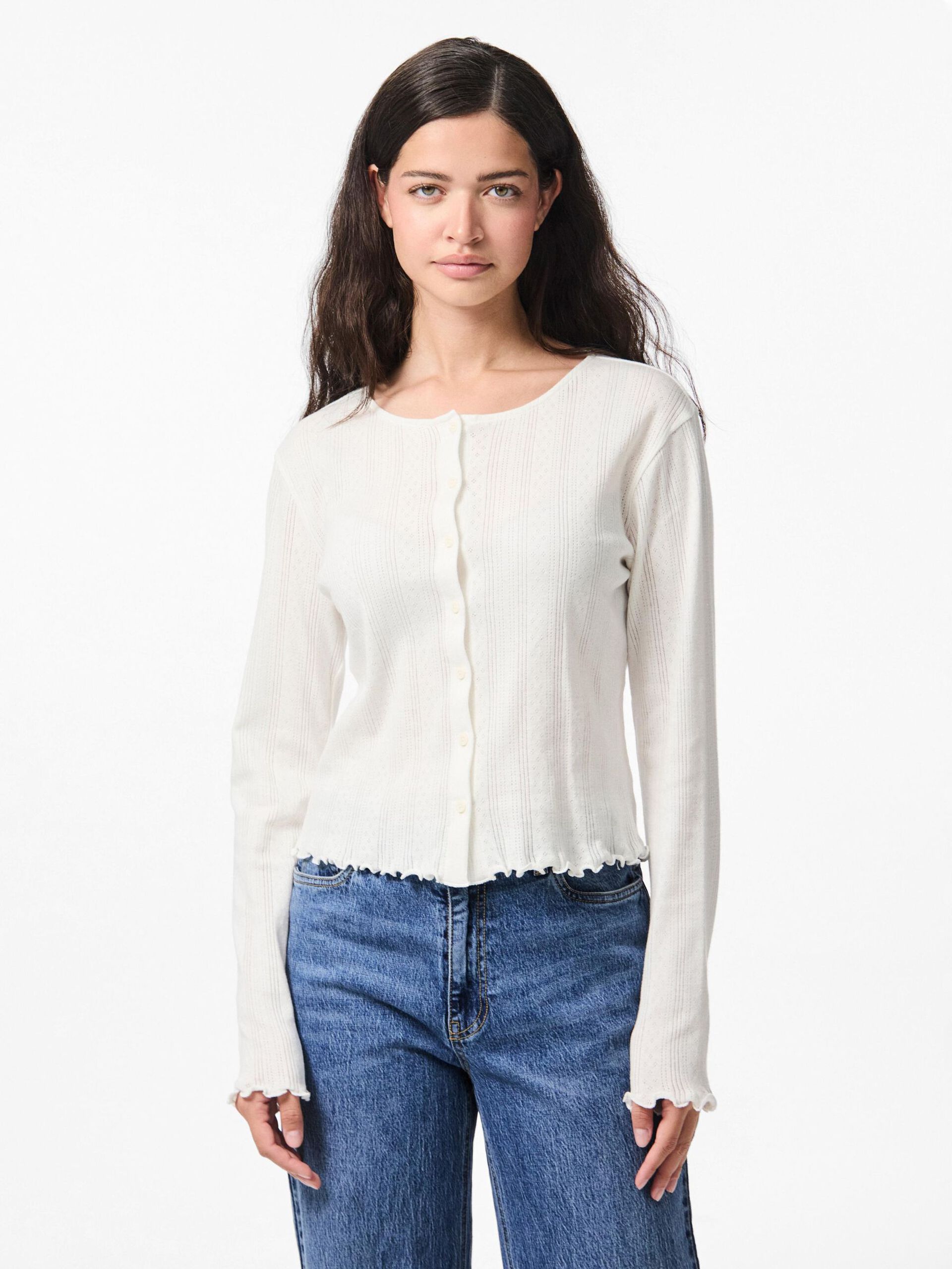 Woman wearing a white blouse and blue jeans on a white background
