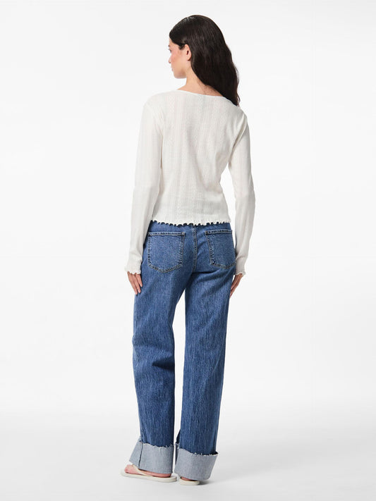 Woman wearing a white blouse and blue jeans on a white background