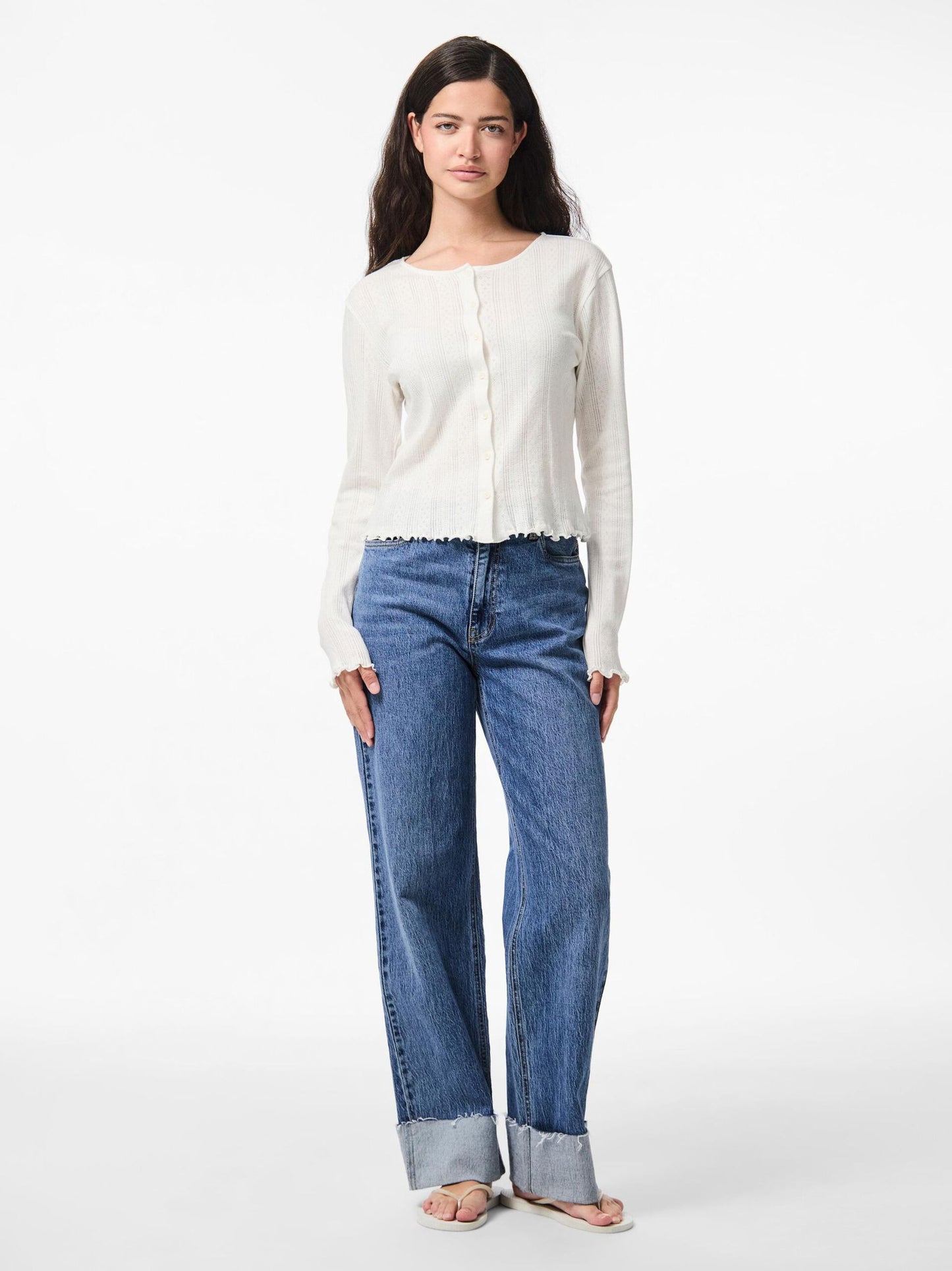 Woman wearing a white blouse and blue jeans on a white background
