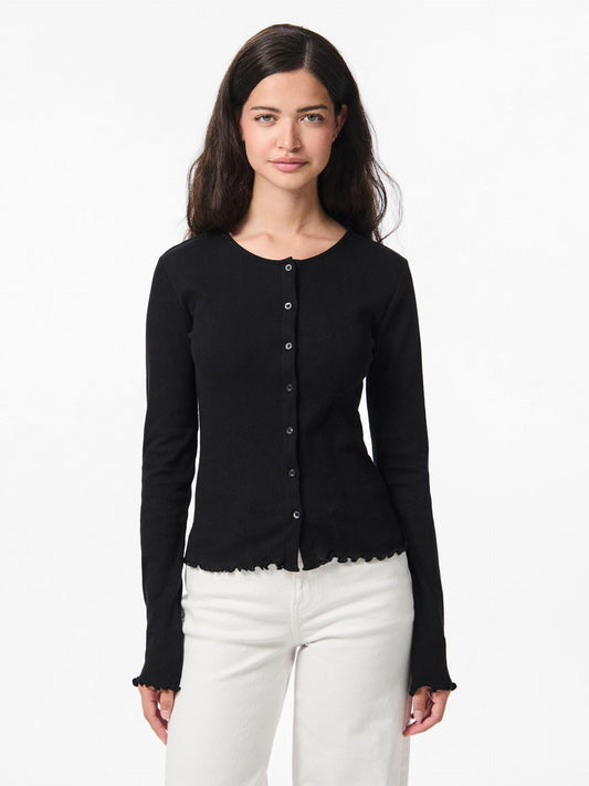 Woman wearing a black long-sleeve top with buttons on a white background
