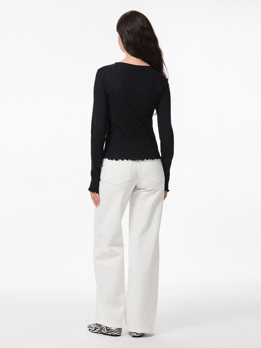 Woman wearing a black top and white pants on a white background