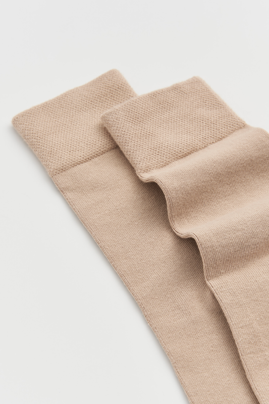 Pair of beige tights on a light gray background