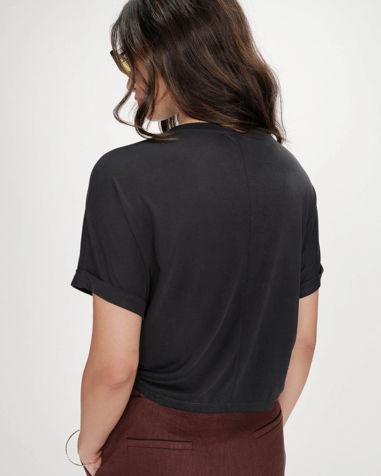 Person wearing a black t-shirt on a plain background