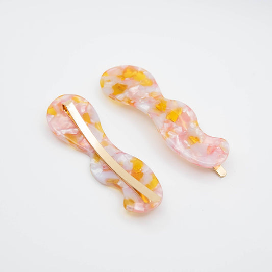 Two hair clips with a marbled design on a white background