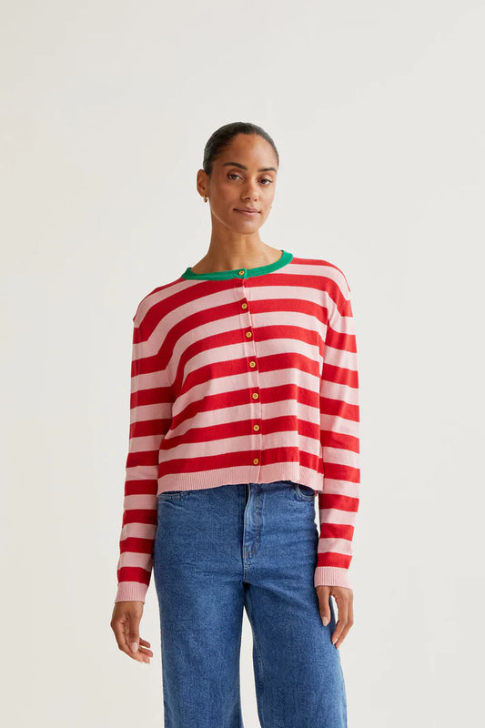 Person wearing a red and white striped sweater with blue jeans on a plain background