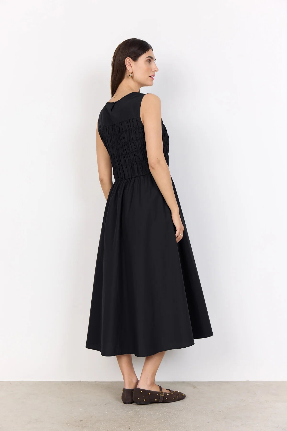 model in a black dress on a white background