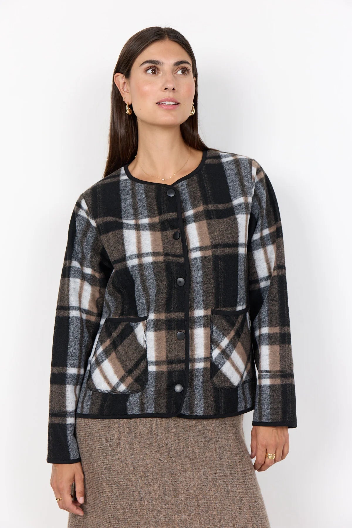 Woman wearing a plaid jacket against a white background