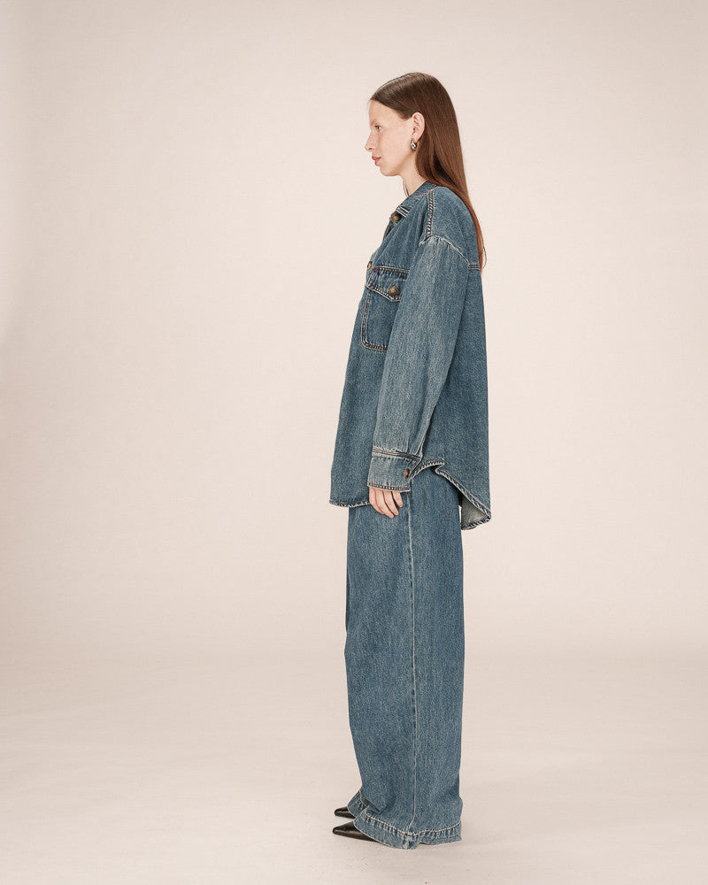 Person wearing a denim outfit on a plain background