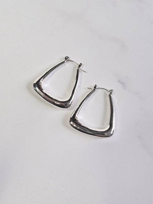 Silver hoop earrings on a light gray background