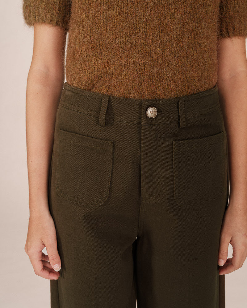 green pants worn by a person on a plain background