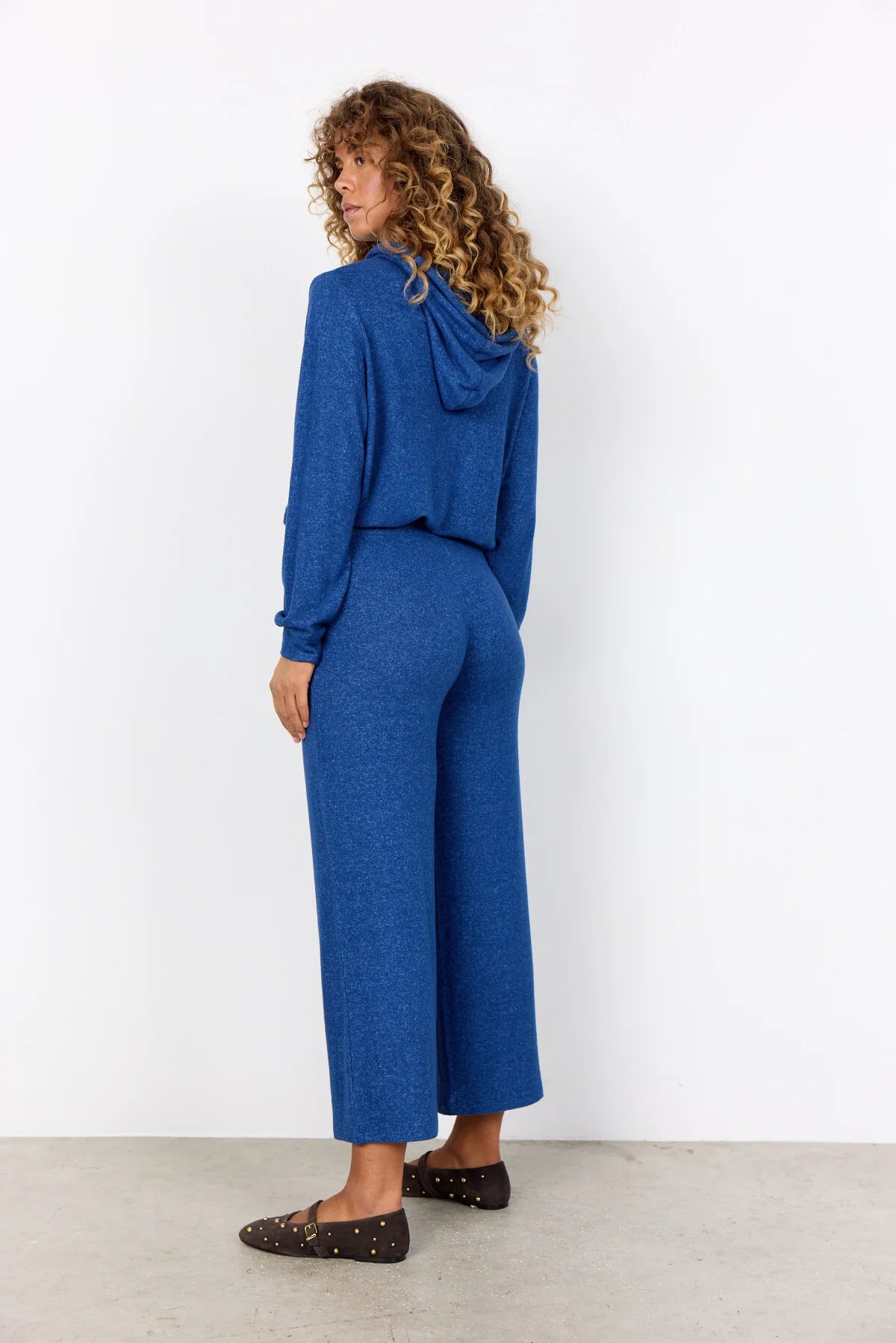 Woman wearing a blue outfit against a white background