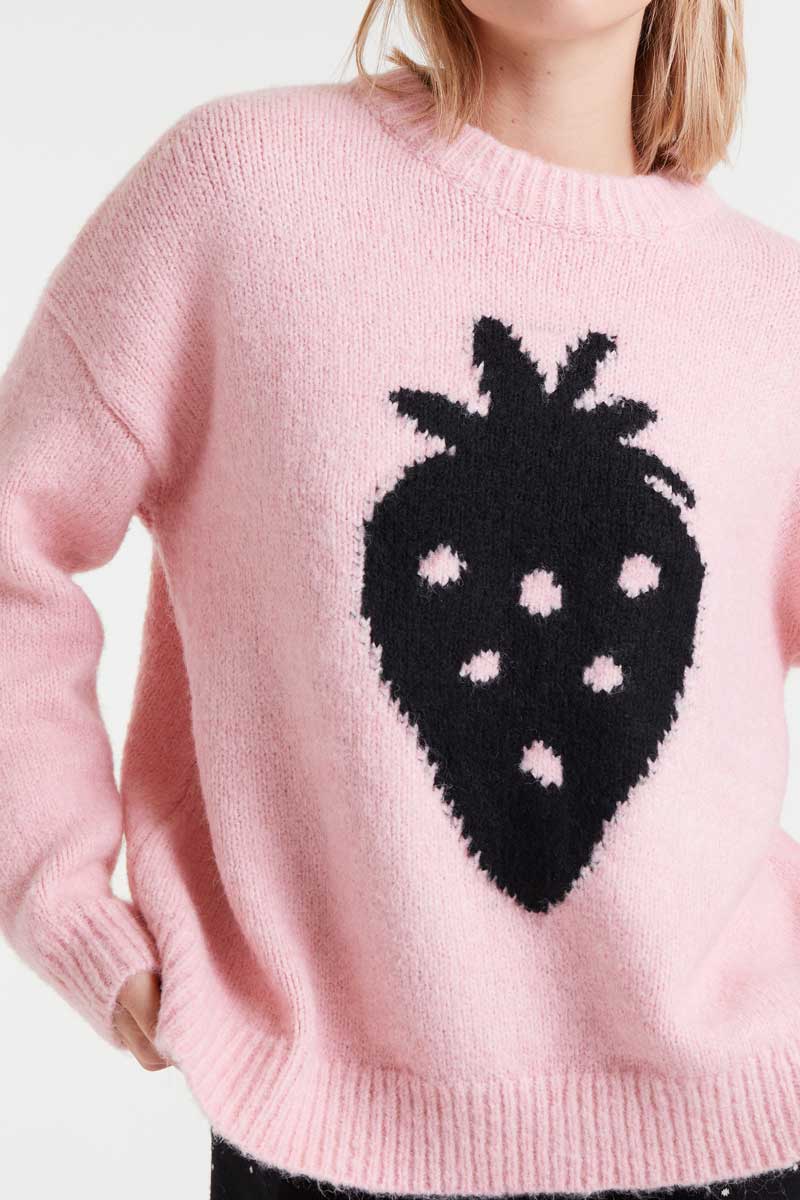 Pink sweater with a black strawberry design on a white background