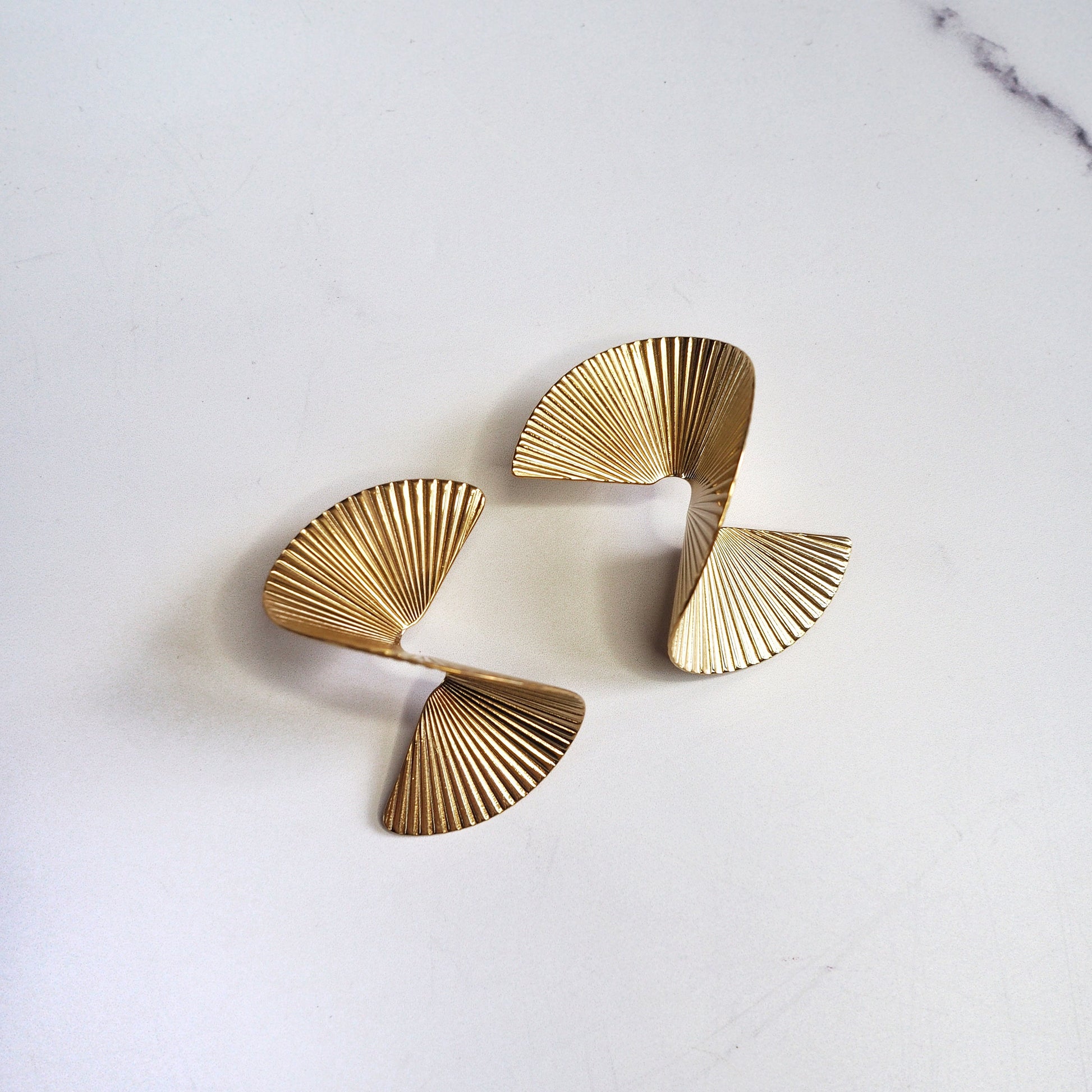 Pair of gold earrings on a light gray background