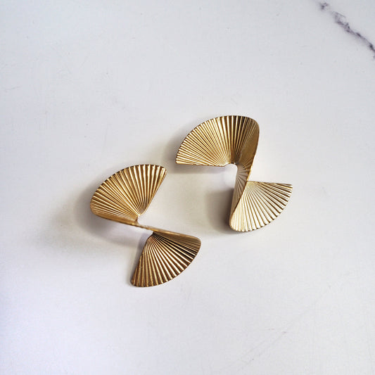 Pair of gold earrings on a light gray background