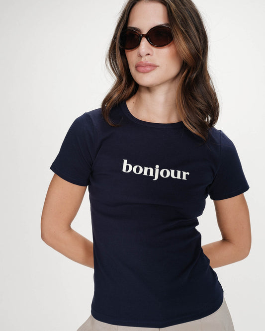 Woman wearing a navy blue t-shirt with 'bonjour' text on a white background