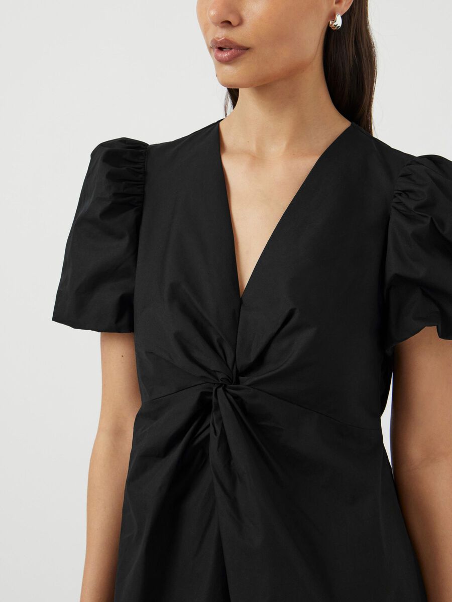 Black dress with puff sleeves on a plain background