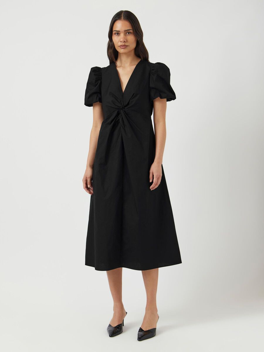 Woman wearing a black dress with puff sleeves on a white background
