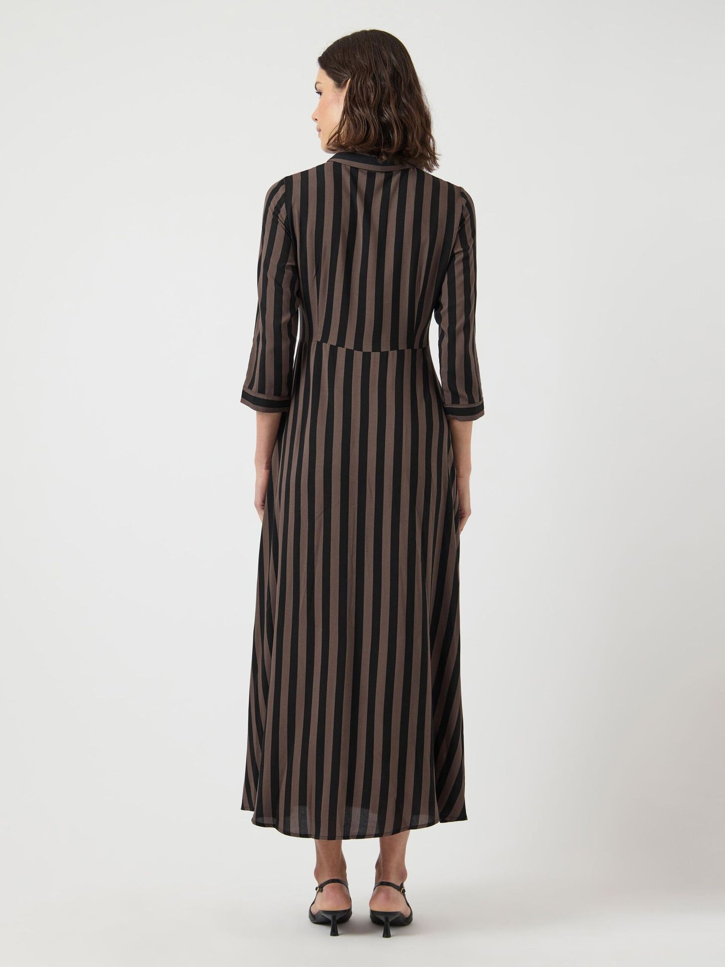 Woman wearing a black and brown striped dress on a white background