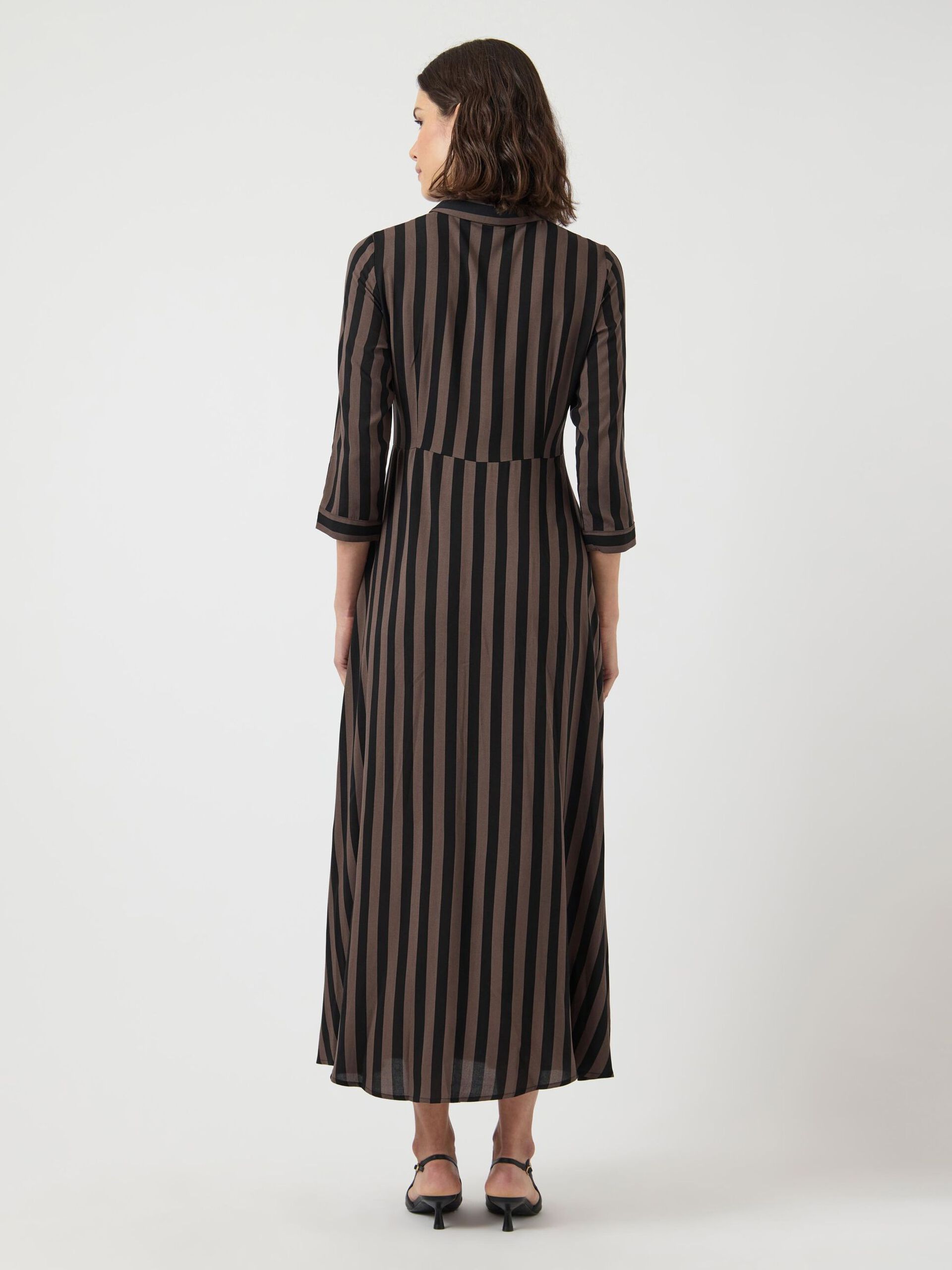 Woman wearing a black and brown striped dress on a white background