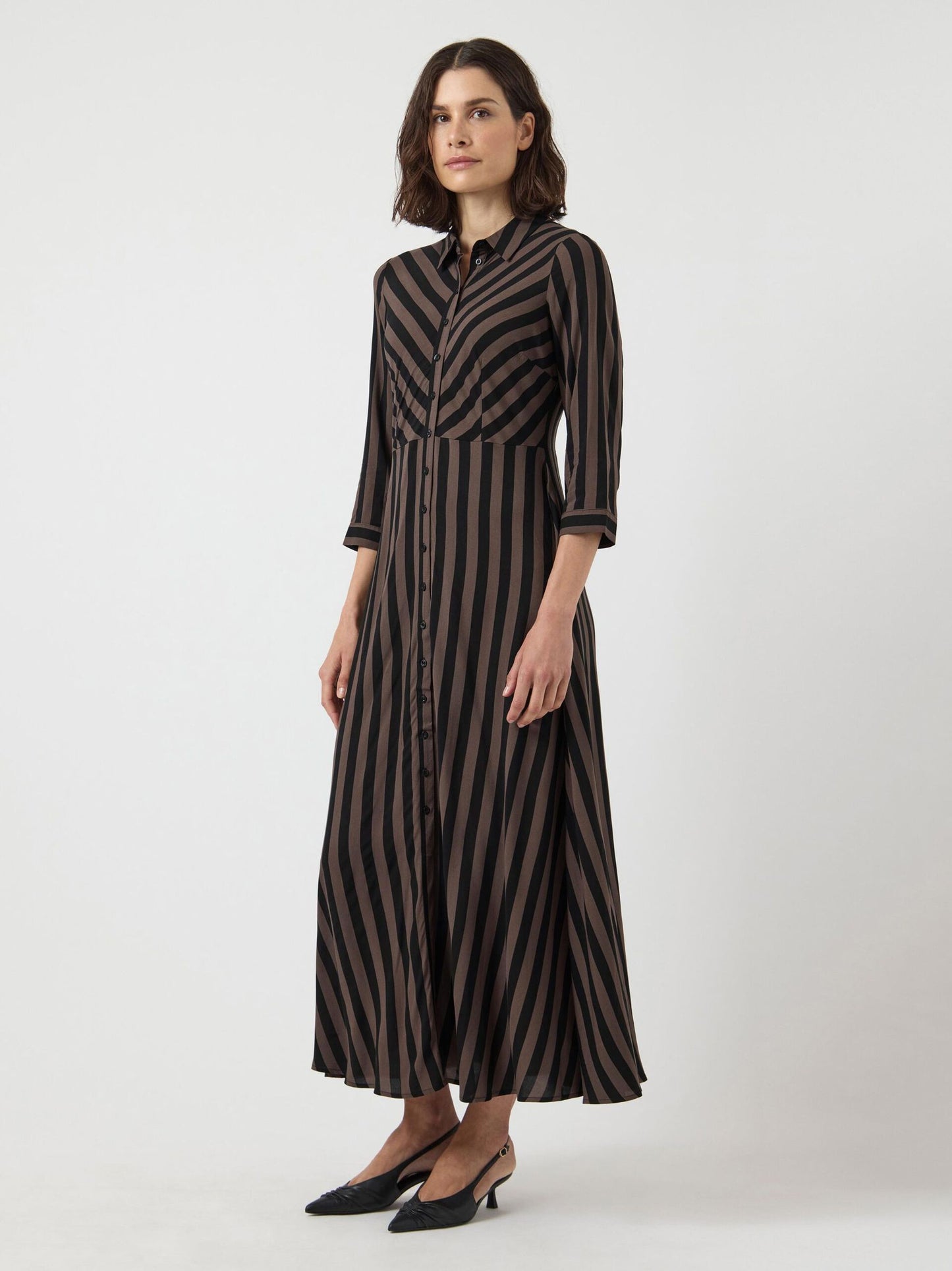 Woman wearing a black and brown striped dress on a white background