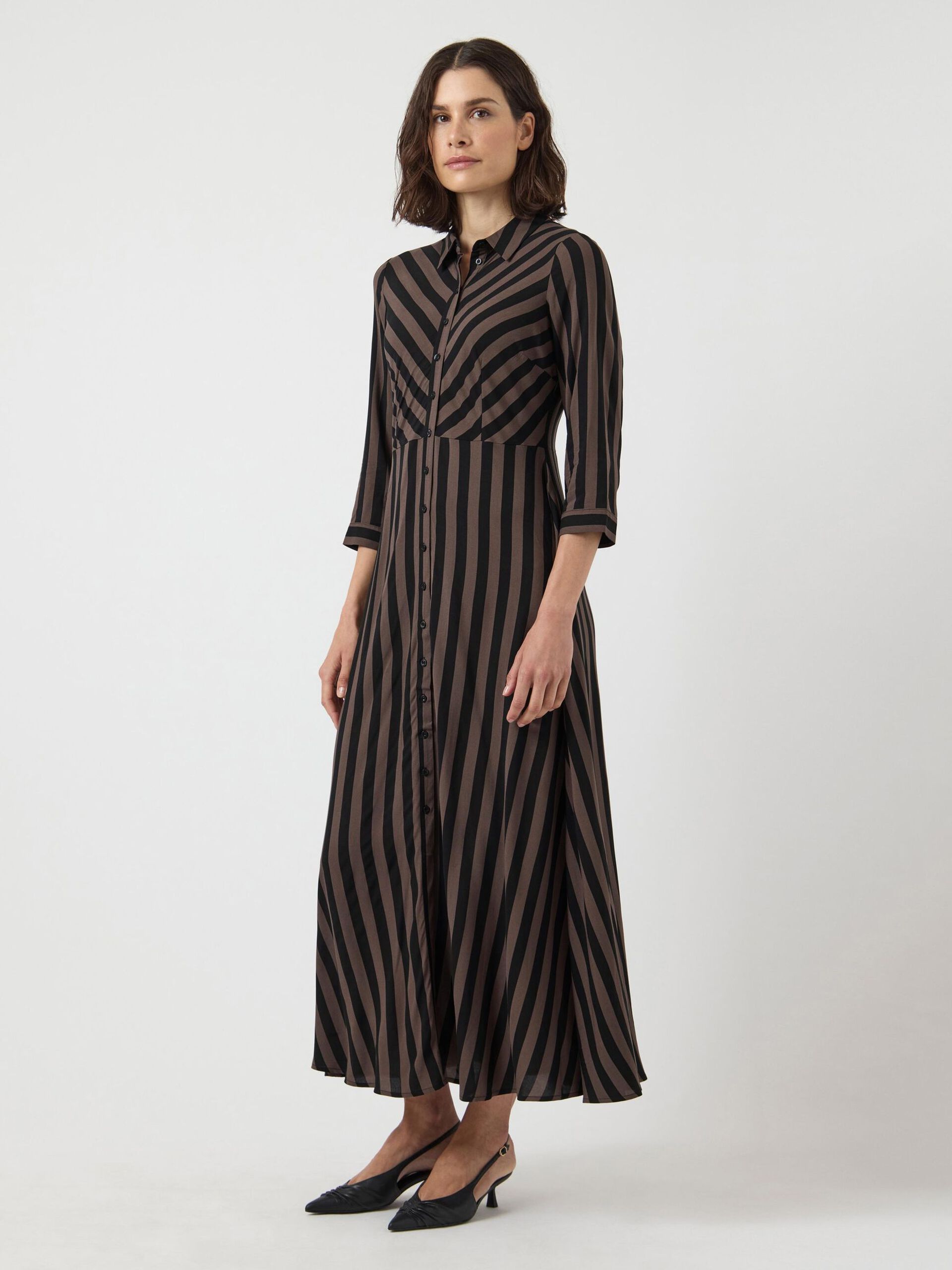 Woman wearing a black and brown striped dress on a white background