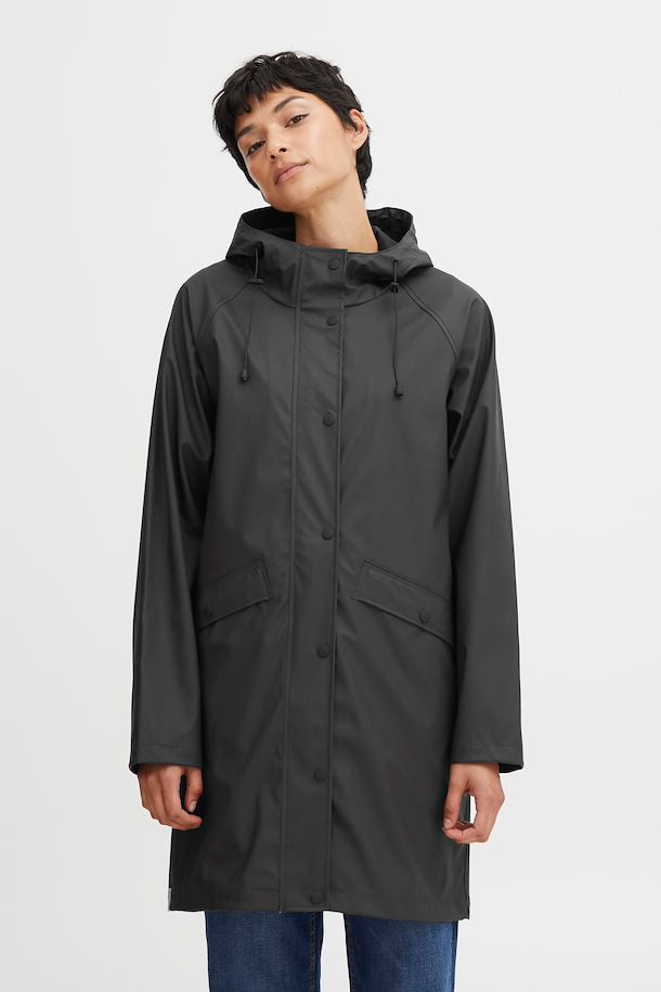 person in a black raincoat with a white background