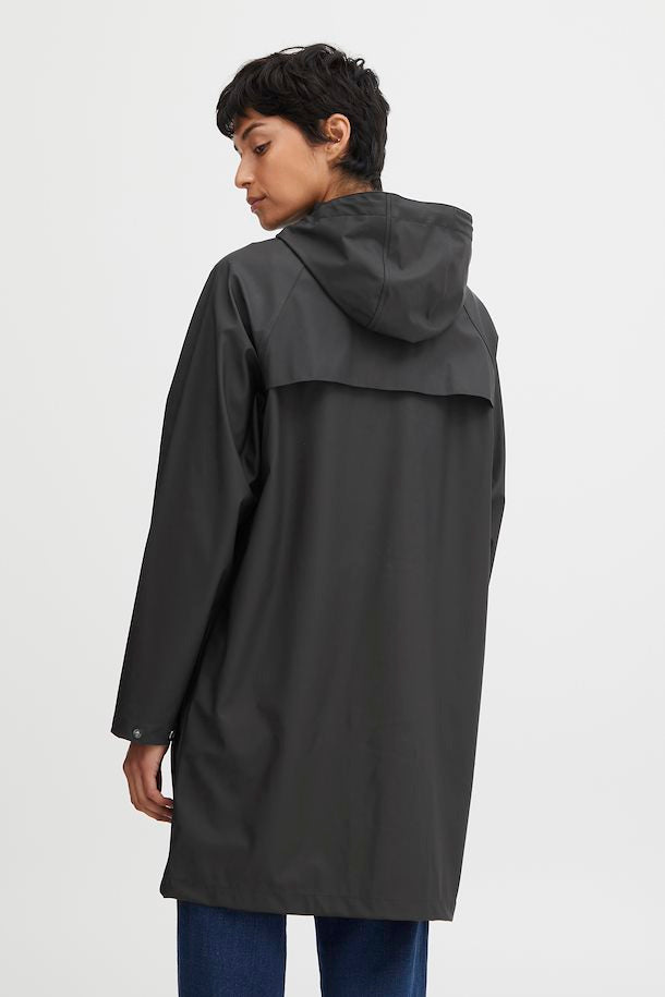person in a black raincoat with a white background