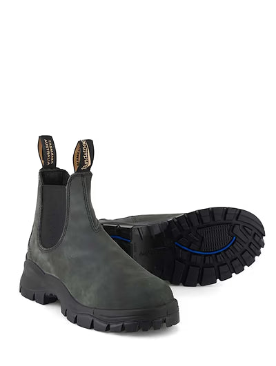 Gray Chelsea boots with black soles on a white background