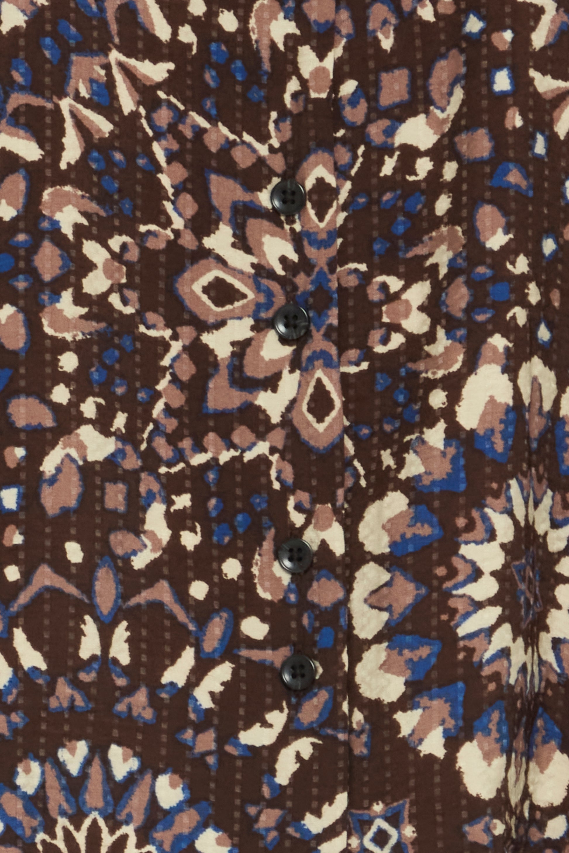 Close-up of a patterned fabric with brown, blue, and beige colors.